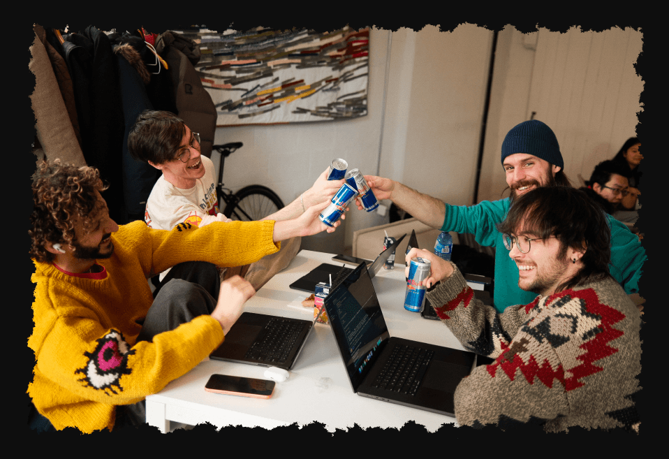 participants cheering with drinks at a hackathon table